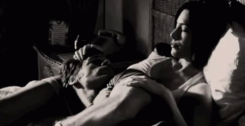 She strokes his head as he lies across her belly