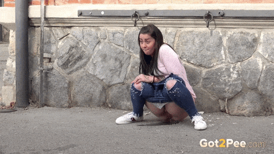 A shy and desperate European amateur pissing in front of a building
